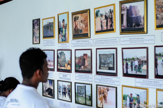 A visitor to the Battle of Elephant Pass memorial looks at the framed photographs depicting many happenings labelled around Elephant Pass. From photos of Coporal Gamini Kularatne who single handedly destroyed an LTTE modified armoured bulldozer with a handful of grenades to Gotabya Rajapaksha visiting the memorial. Today a statue of the fallen hero stands tall whilst a few feet away the defeated armoured vehicle is parked. 